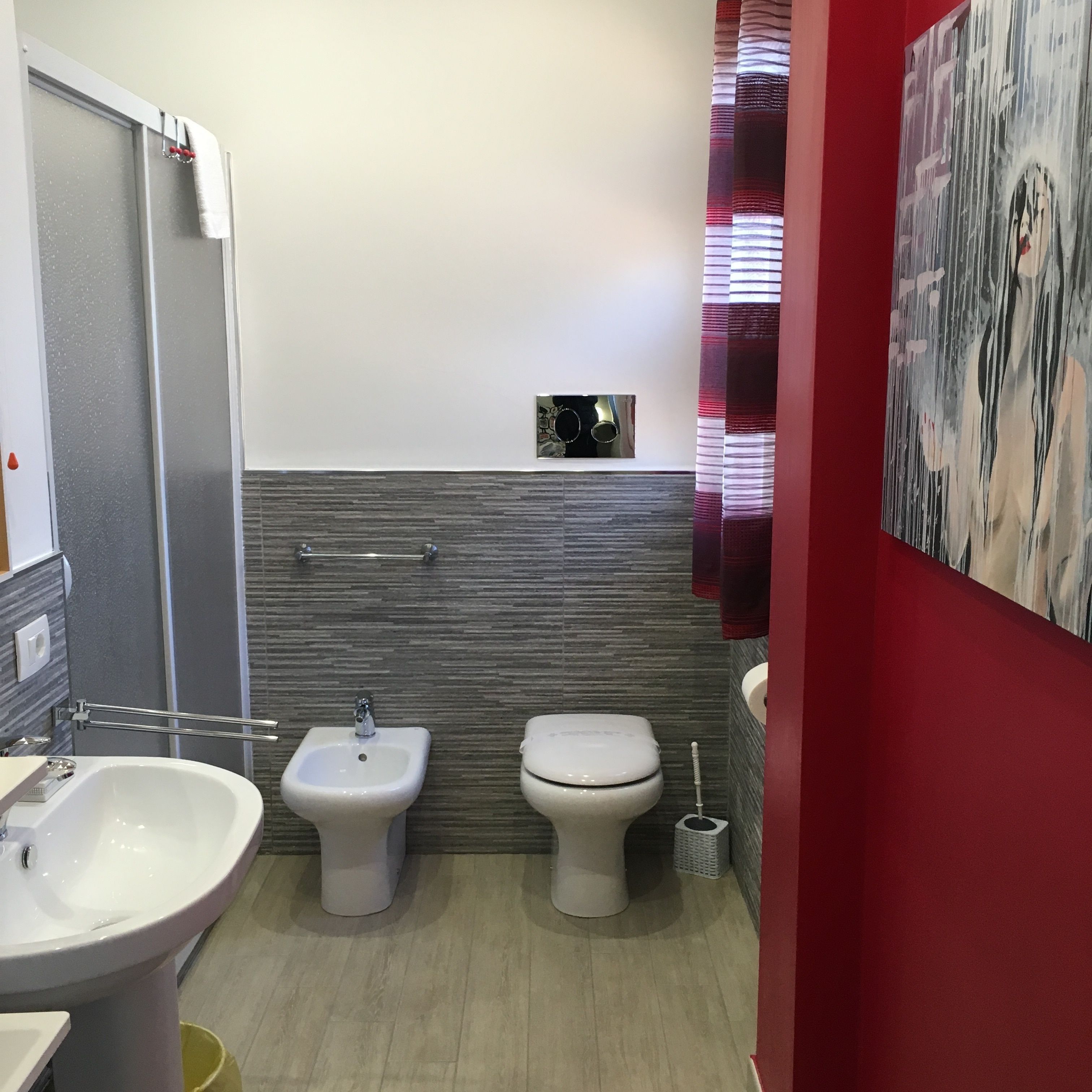 A bathroom with a bidet, toilet, and sink.