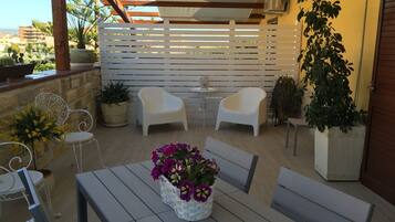 Relax in a serene outdoor space with a pergola, comfortable seating, and lush greenery.