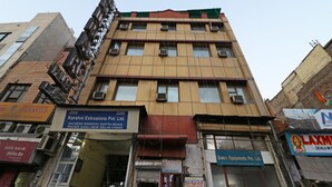 A multi-story building with various businesses including a bank, a hotel, and a company named 'Karshni Extrusions Pvt. Ltd.' - OYO 10562 Paharganj (New Delhi)