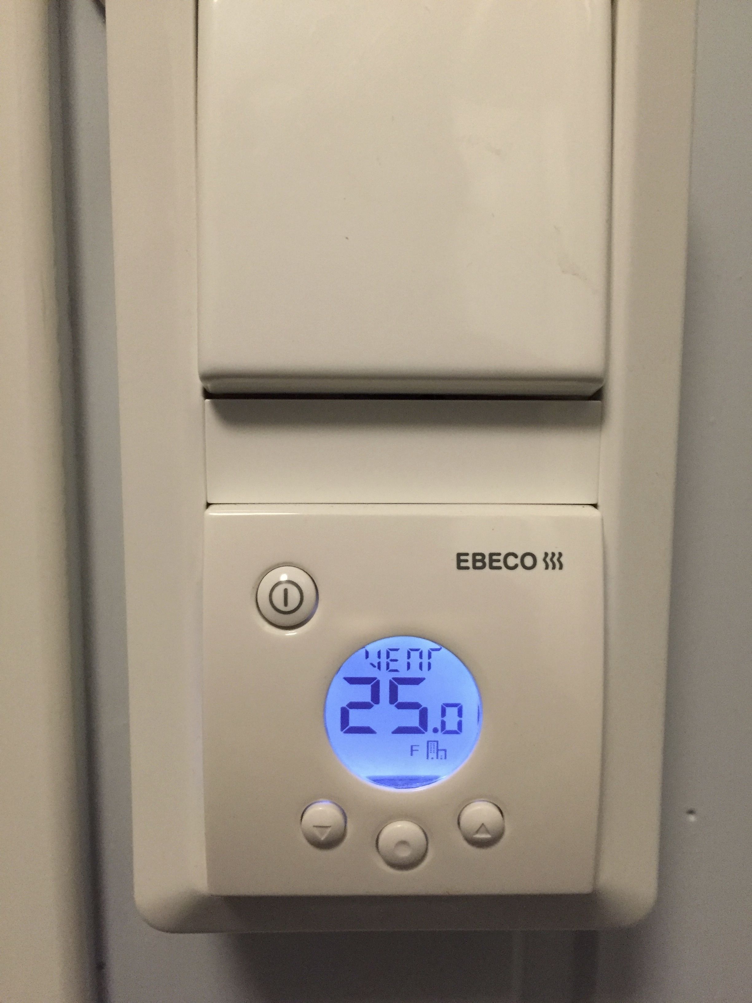 Termostaatti, jossa on digitaalinen näyttö, ja jossa lämpötila on 25,0 astetta Celsius-asteikolla.