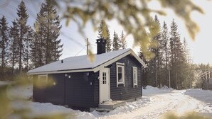 A small cabin with a dark exterior, a chimney, and a snow-covered ground. - Koselig Hytte i Hemsedal (Hemsedal)