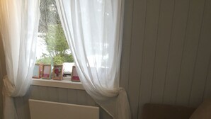 A cozy living room with a marble table, a wooden tray with oranges, a beige sofa, and a window with sheer curtains. - Koselig Hytte i Hemsedal (Hemsedal)