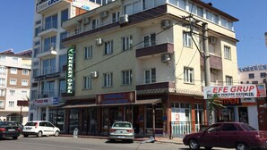 Un edifici d'altes plantes amb diversos negocis a la planta baixa, com ara un restaurant i una productora.