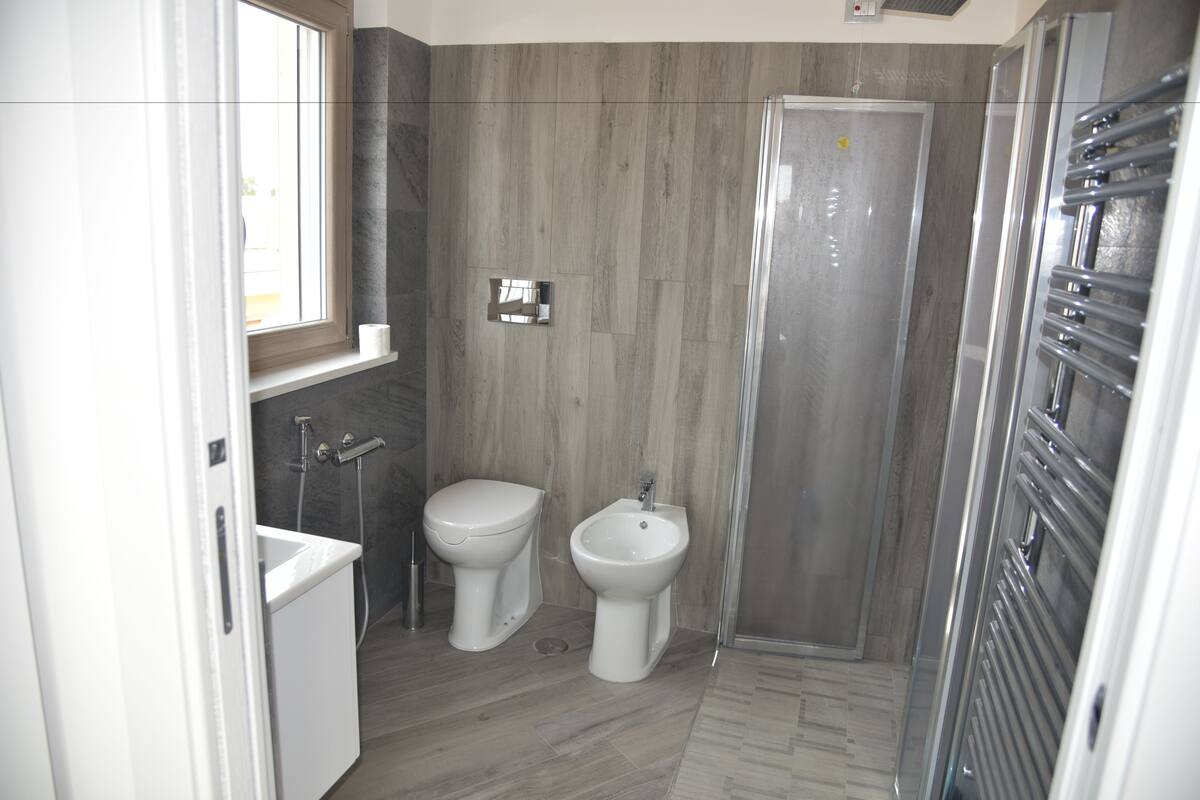 A modern bathroom with a toilet, bidet, and shower.