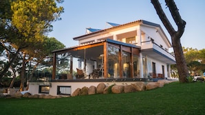 Uma casa moderna com uma estufa de vidro, grandes janelas e um caminho de pedra.