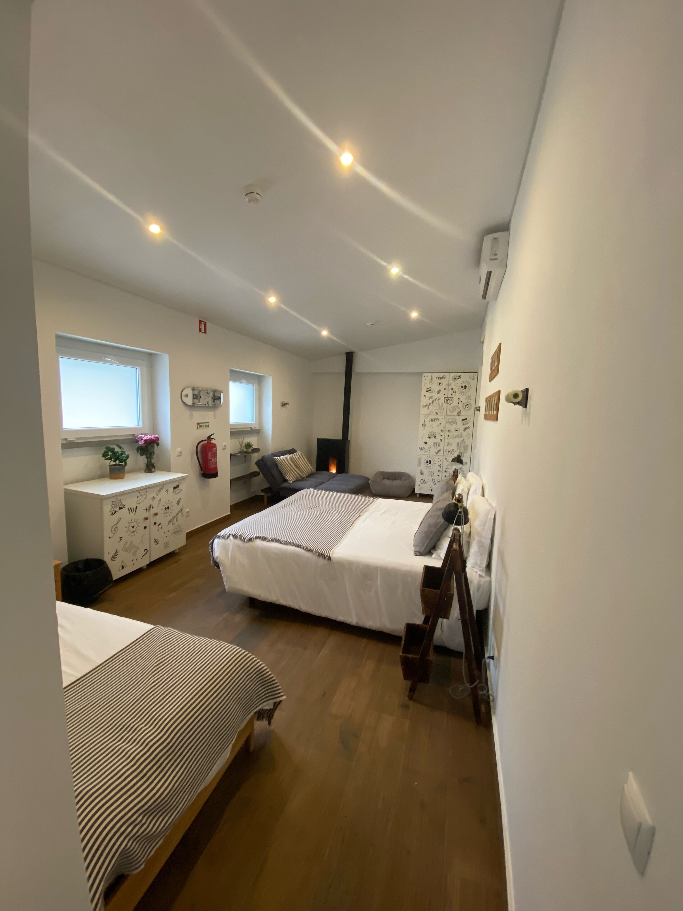 A bedroom with a bed, a desk, a chair, and a window.
