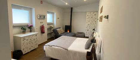 A bedroom with a bed, a desk, a chair, and a window.