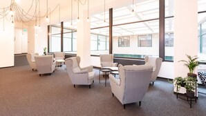 A modern office space with checkered chairs, a round table, and pendant lighting. - Narodni Stay (Prague)