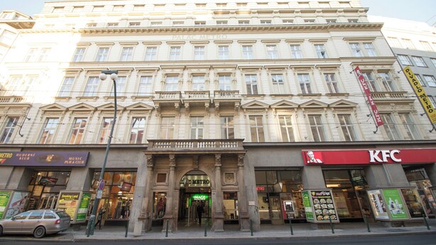 A multi-story building with a classical architectural style, featuring a prominent entrance with columns and a large arched doorway. - Narodni Stay (Prague)