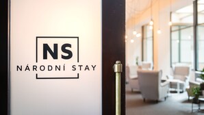 A hotel entrance with a glass door featuring the logo "NS NÁRODNÍ STAY". - Narodni Stay (Prague)