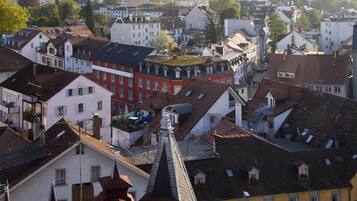 A densely packed urban area with various buildings, including a prominent red building with a unique roof structure.