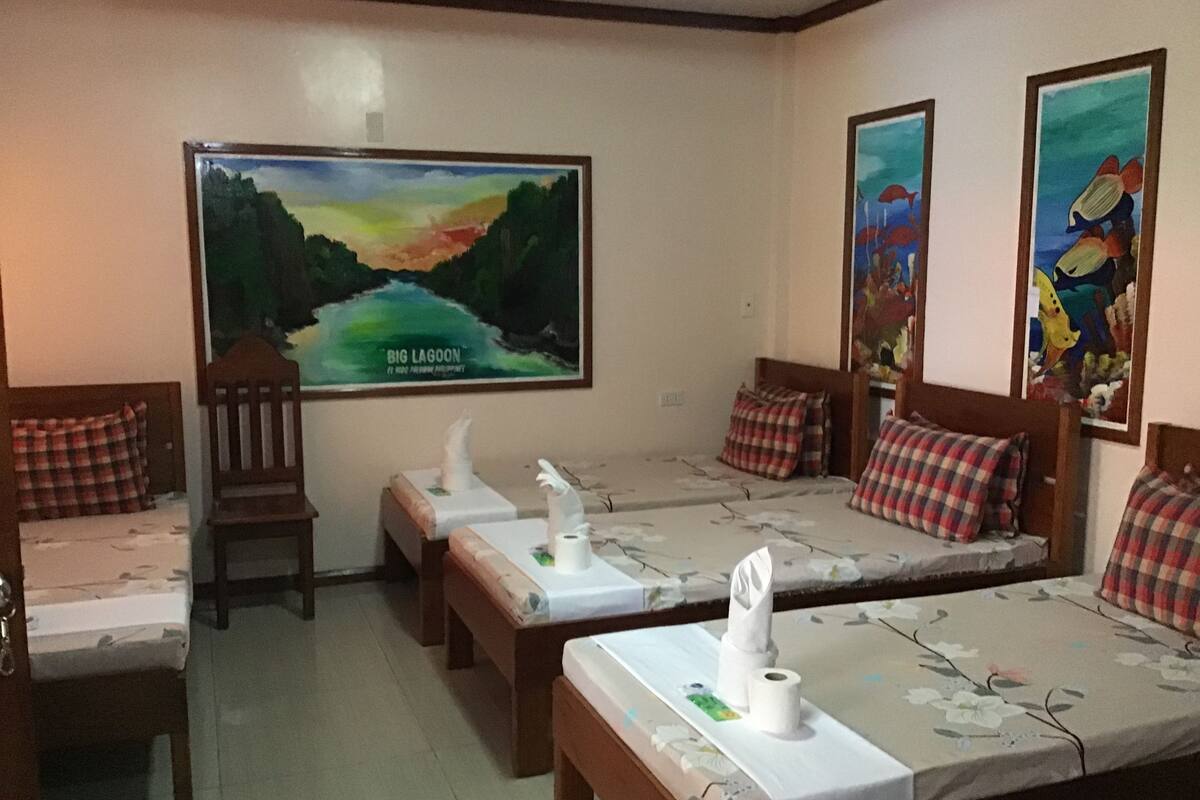 A hotel room with two beds, a chair, and a large painting of a landscape.