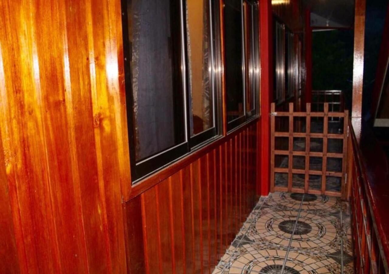A wooden hallway with a tiled floor and a wooden fence.