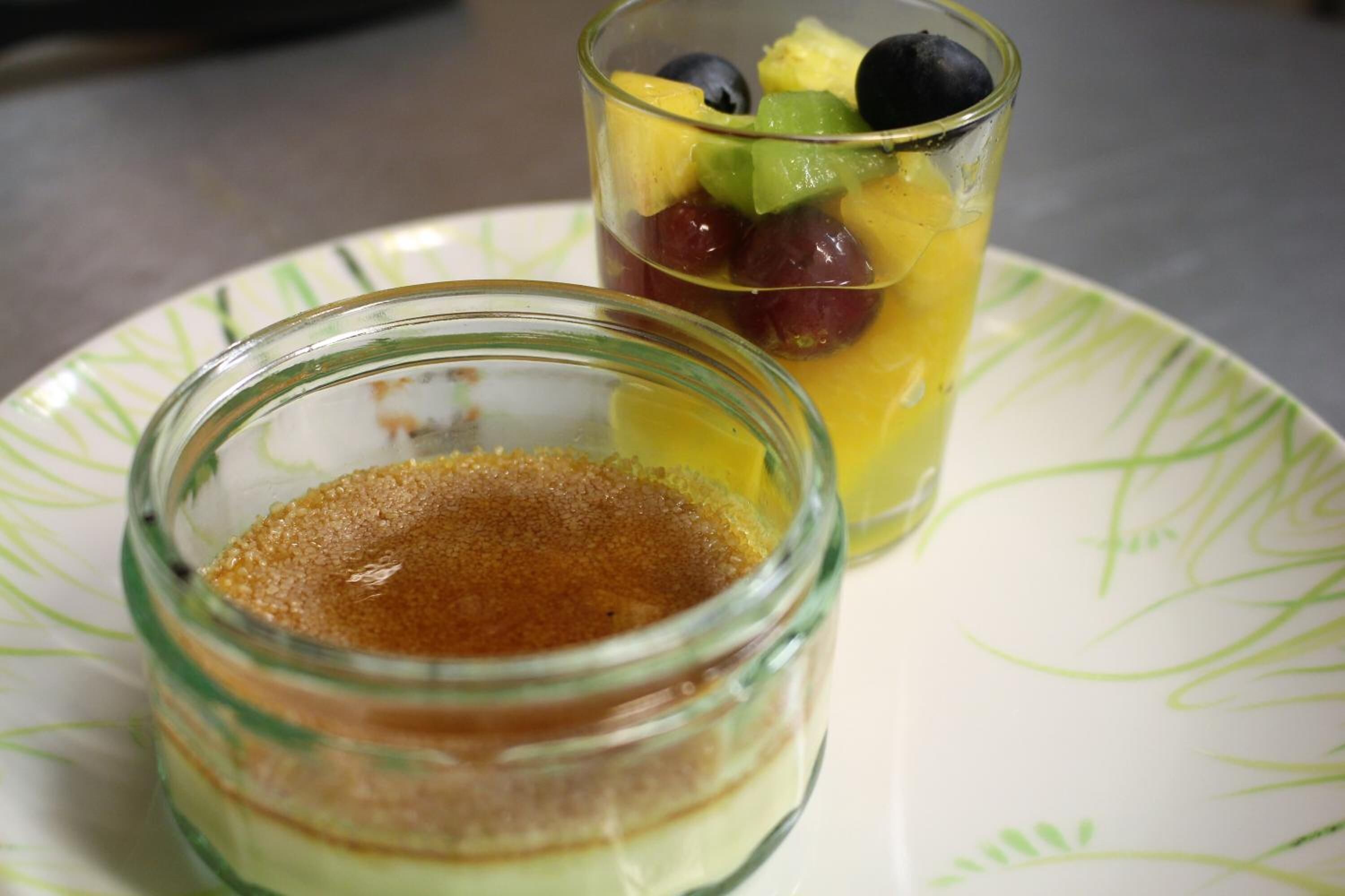 Ein Dessert bestehend aus einem Schichttorte und einem Fruchtsaft auf einem Teller.