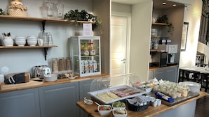 A breakfast buffet area with various food items and beverages. - Sockerslottet hotell (Kristinehamn)