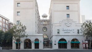 A large, white, two-story building with a central clock and arched entrances. The building has a sign that reads "Fairfield Marriott." - Fairfield by Marriott Shanghai Jingan (Shanghai)