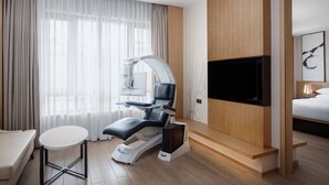 A modern hotel room with a medical examination chair, a flat-screen TV, a bed, and a small table. - Fairfield by Marriott Shanghai Jingan (Shanghai)