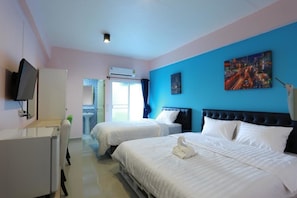 A hotel room with two beds, a TV, a desk, and a bathroom.