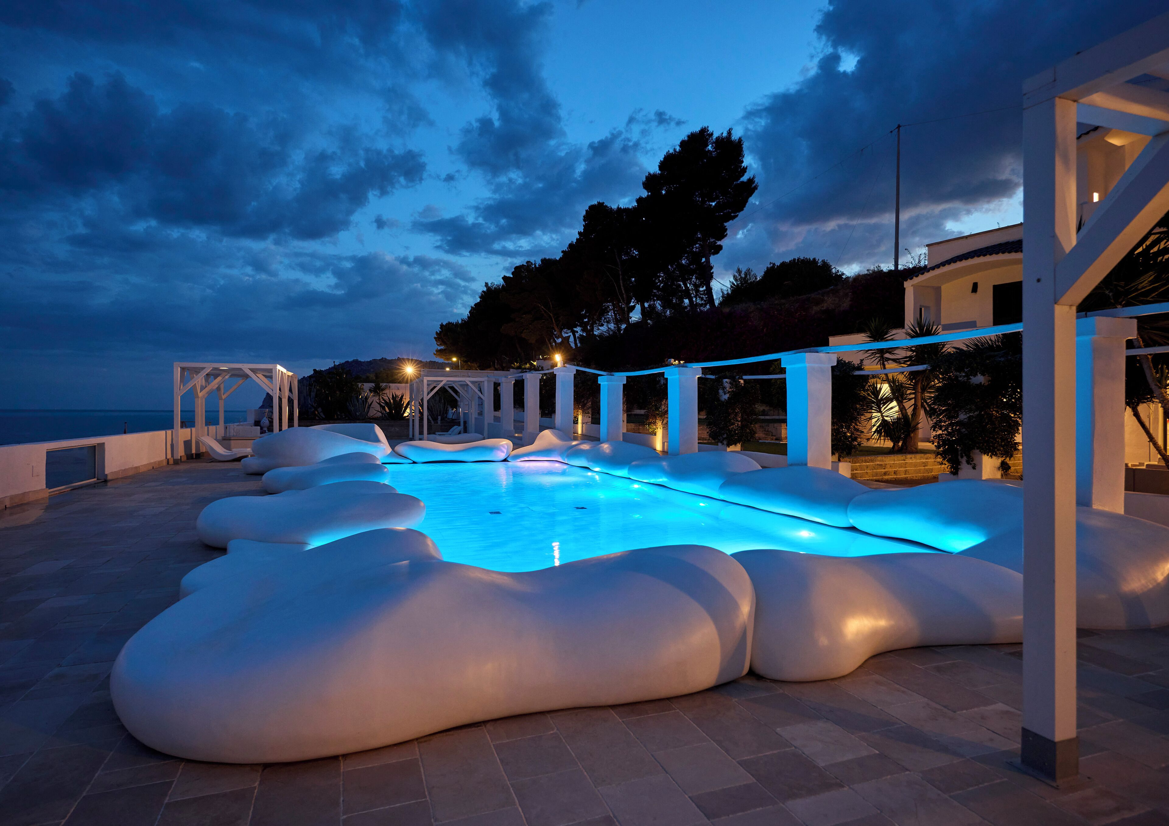 A pool area with a unique design, including a white structure and seating areas.