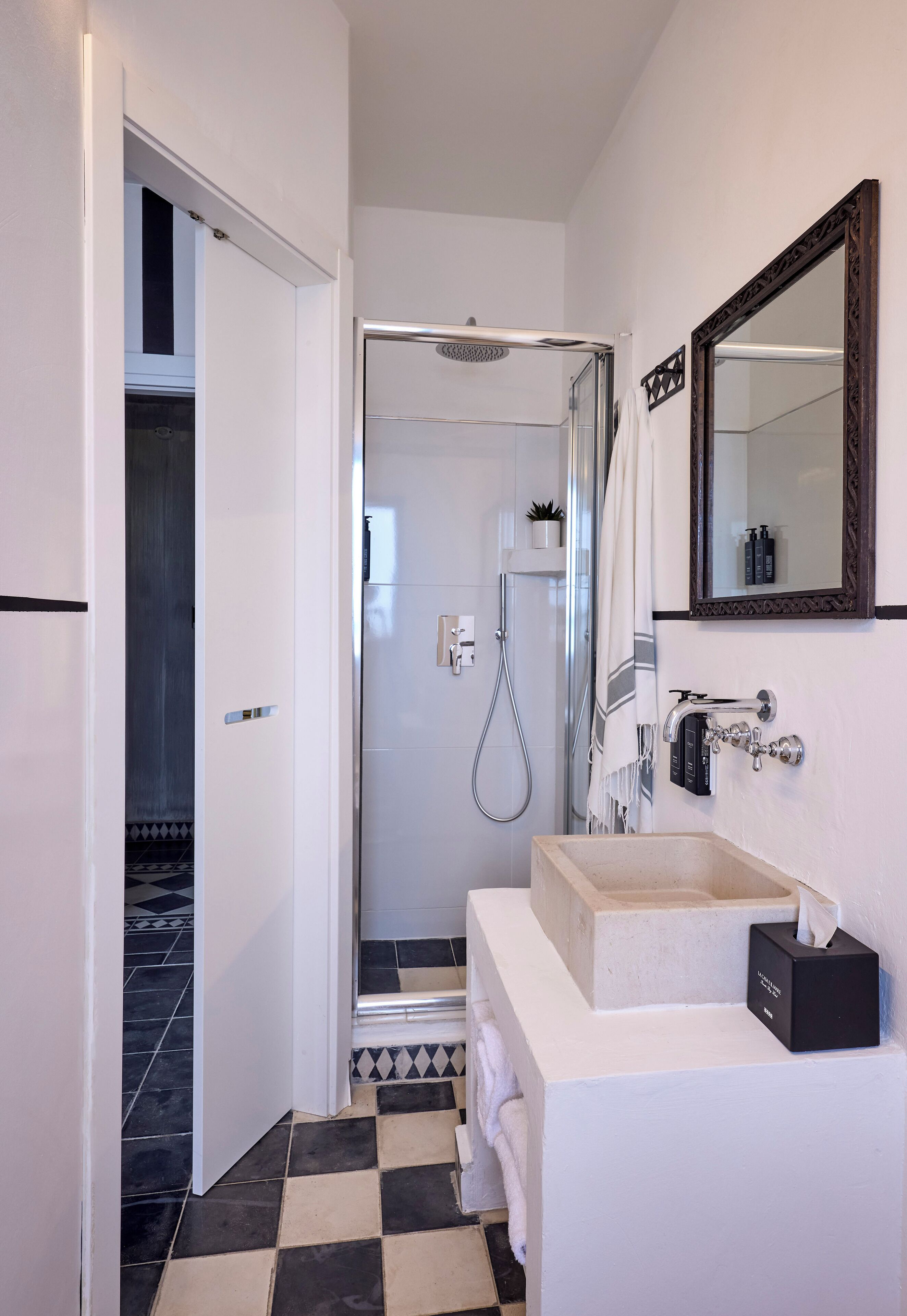 A modern bathroom with a shower, a sink, and a mirror.