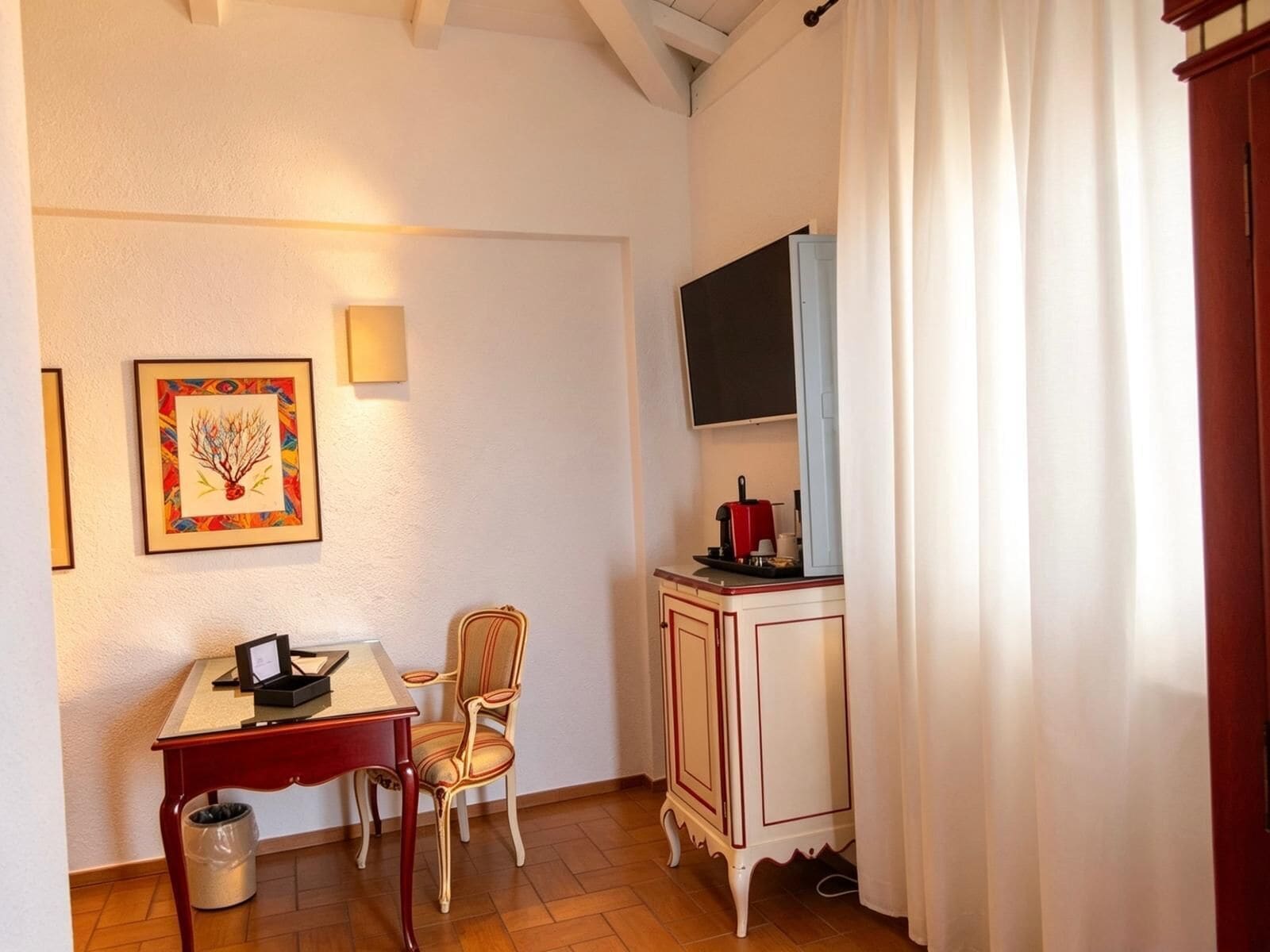 Une pièce comprenant une table à manger, des chaises, un petit meuble, un téléviseur et une œuvre d’art encadrée accrochée au mur.