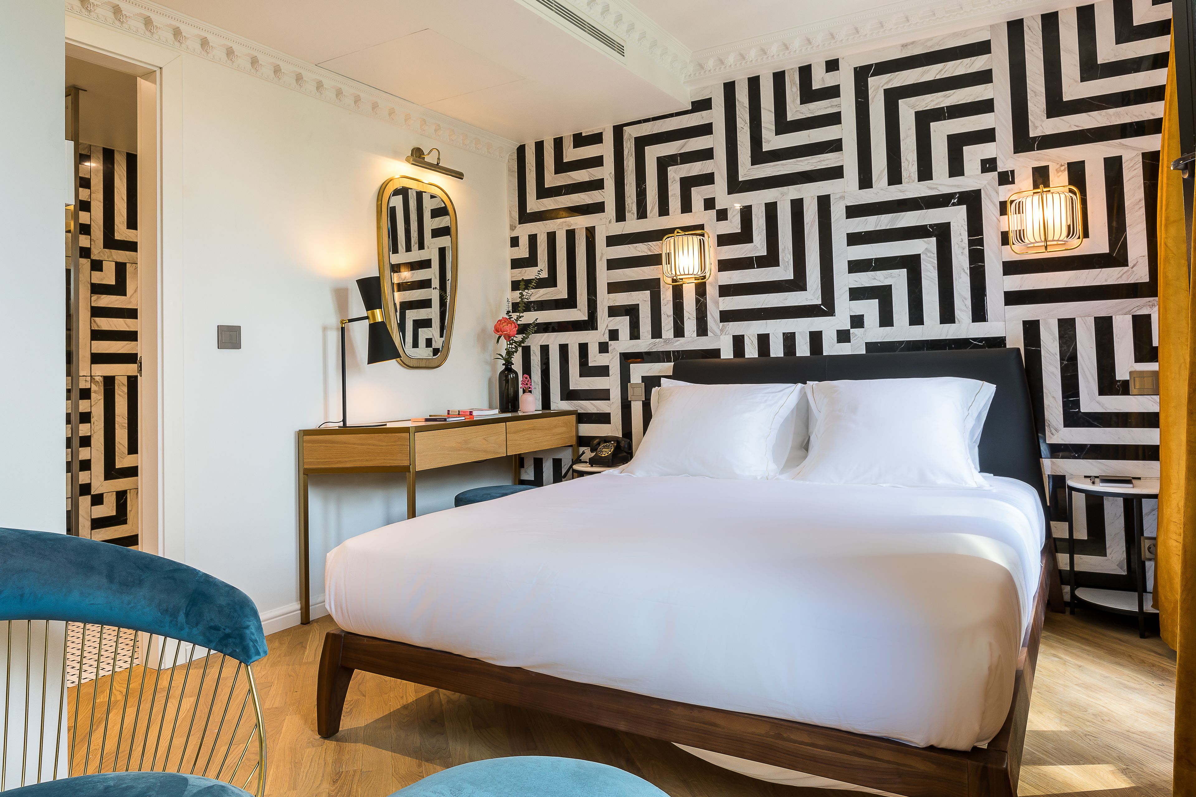 Una habitación de hotel moderna con una cama grande, un escritorio y una silla.