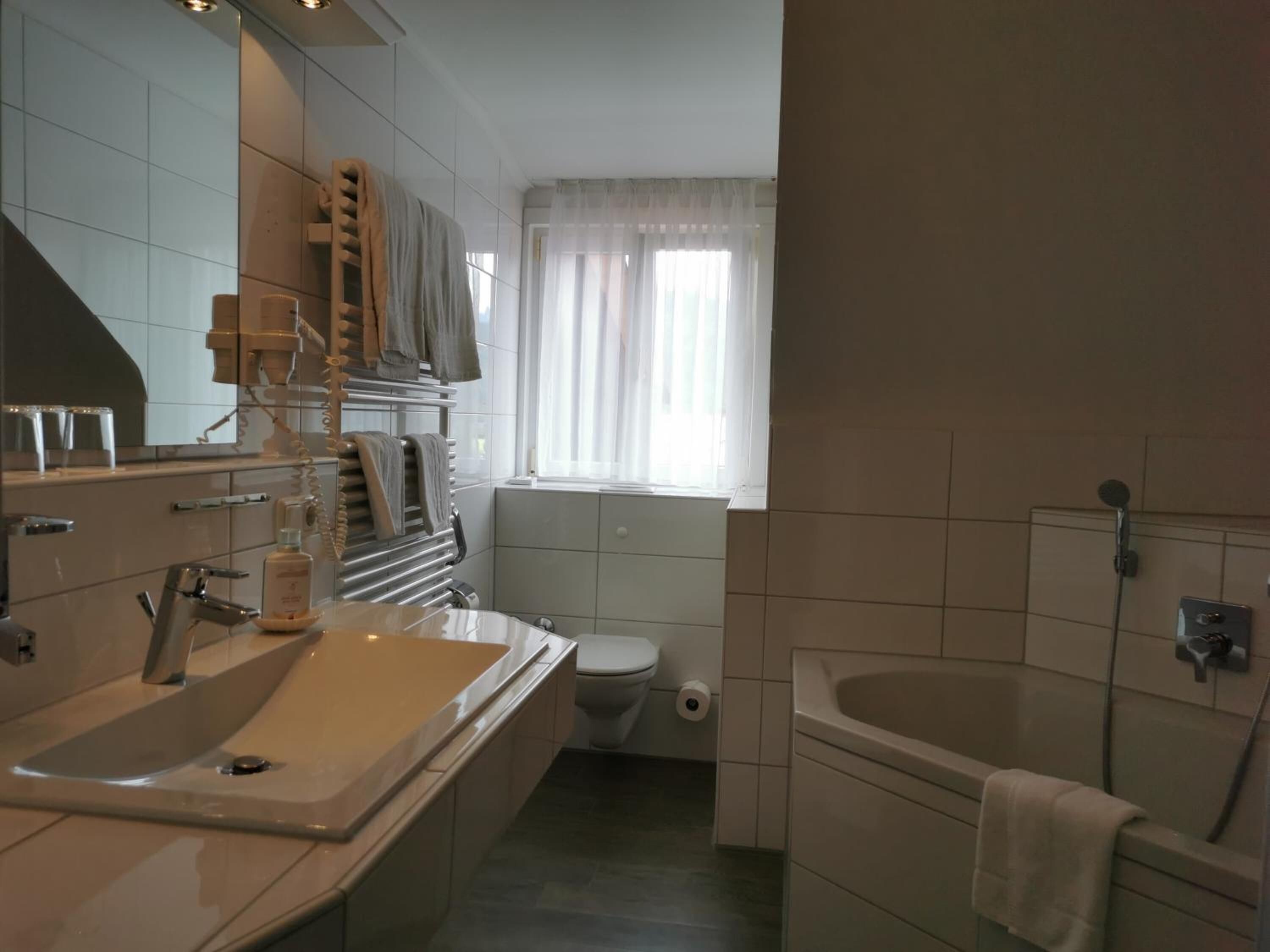 Un baño moderno con un lavamanos grande, inodoro y bañera.