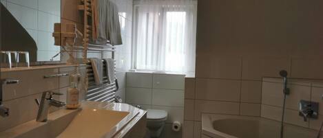 Un baño moderno con un lavamanos grande, inodoro y bañera.