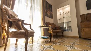A living room with a patterned floor, a wooden cabinet, and a small table with a book.