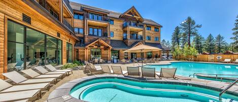 Alberca al aire libre, sombrillas en la alberca y camastros