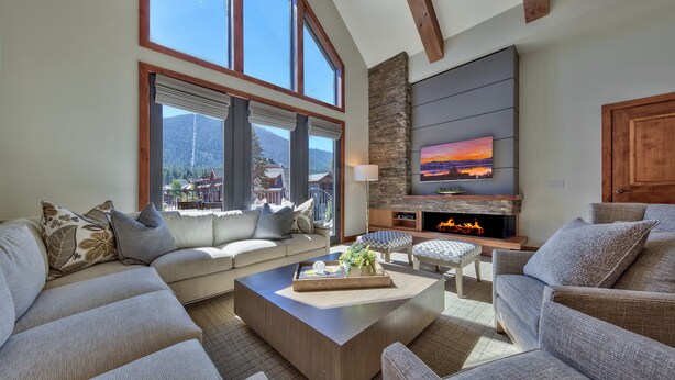 A spacious living room with a large sectional sofa, a wooden coffee table, and a fireplace.