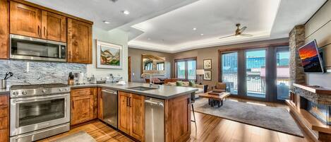 A modern kitchen with wooden cabinets, stainless steel appliances, and a large island.