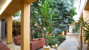 A lobby with a central seating area, a large indoor plant, and a tiled floor. - Bankya Palace (Sofia)