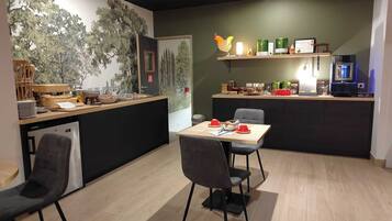 A modern kitchen with a dining area, a counter with various items, and a wall with a mural.