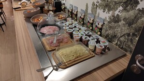 Uma mesa de buffet com diversos alimentos e acompanhamentos.