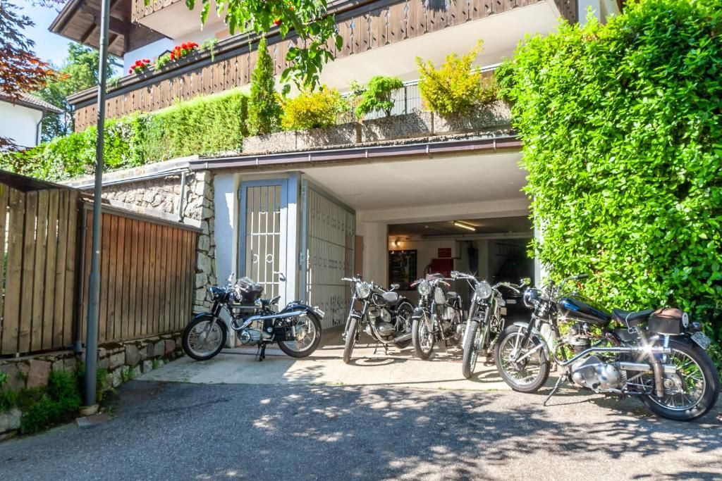 A building with a stone facade, a wooden fence, and a row of parked motorcycles.