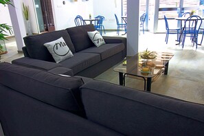 Un espace de vie moderne comprenant un canapé, une table basse et des chaises bleues.