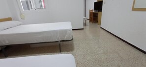 A room with two single beds, a desk with a chair, and a television. - Hostal El Mercat (Villajoyosa)