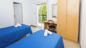 A room with two beds, a desk, a wardrobe, and a door leading outside. - Hostal El Mercat (Villajoyosa)