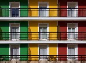 A multi-story building with balconies, each with a black metal railing. - Hostal El Mercat (Villajoyosa)
