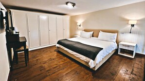 A bedroom with a large bed, wooden flooring, a wardrobe, and bedside lamps. - DayBreak B&B (Naples)
