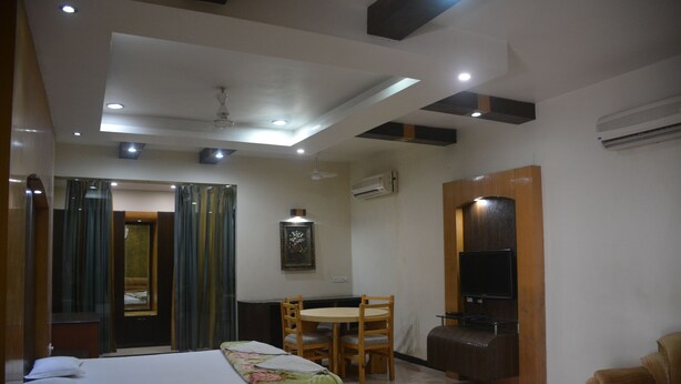 A hotel room with a bed, a desk, a chair, and a television. - Hotel Naveen Residency (Darbhanga)