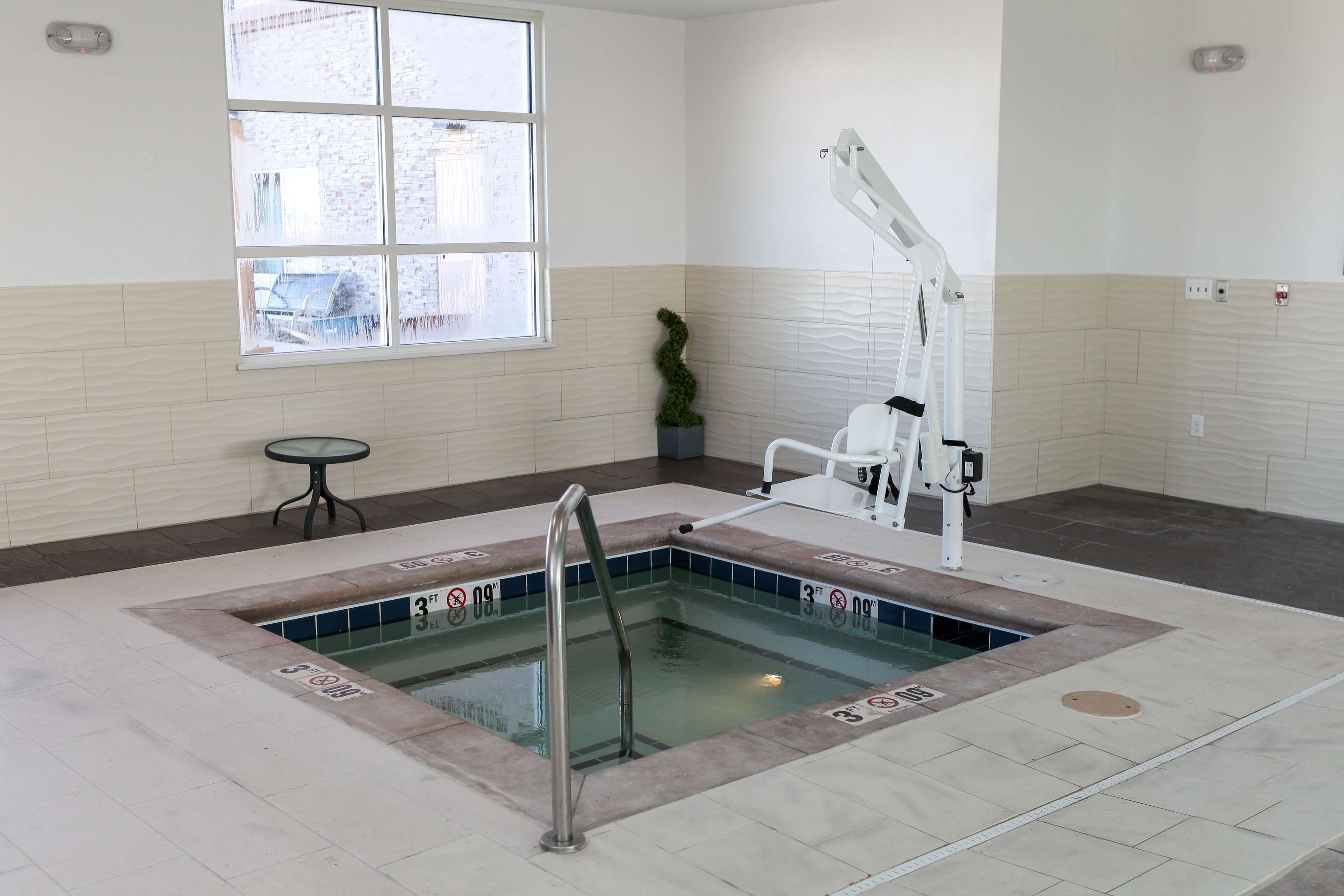 A swimming pool with a lifeguard chair and a window.