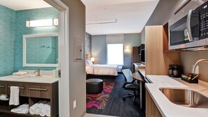 A hotel room with a bathroom, kitchenette, and a bed. - Home2 Suites by Hilton McKinney (McKinney)