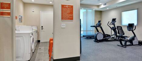 A hotel room with a washing machine, a guest laundry area, and exercise equipment.