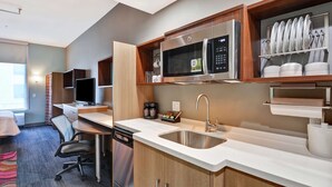 A modern kitchen with a microwave, sink, and dish rack. - Home2 Suites by Hilton McKinney (McKinney)