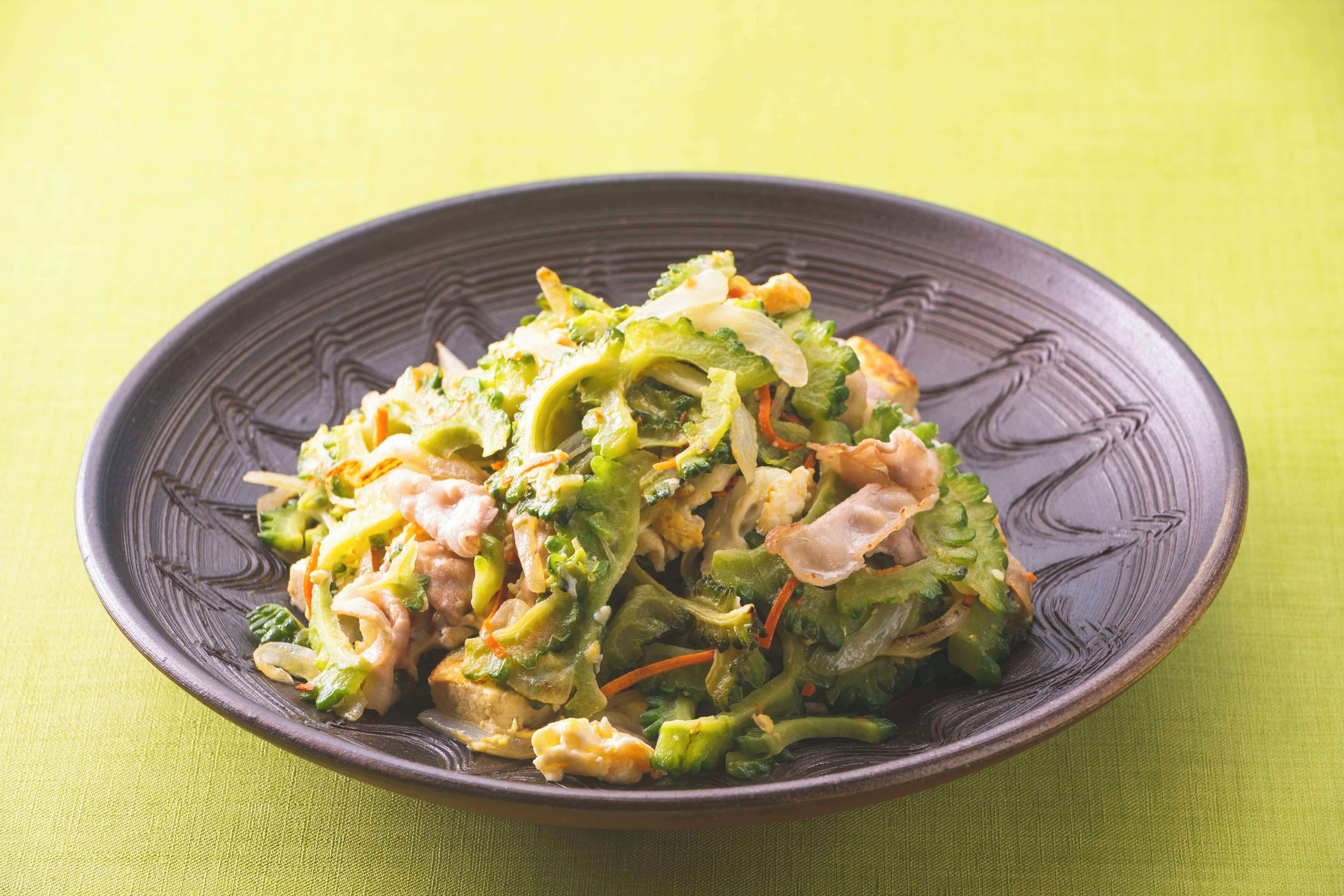Une assiette de légumes sautés, présentée sur une assiette sombre.