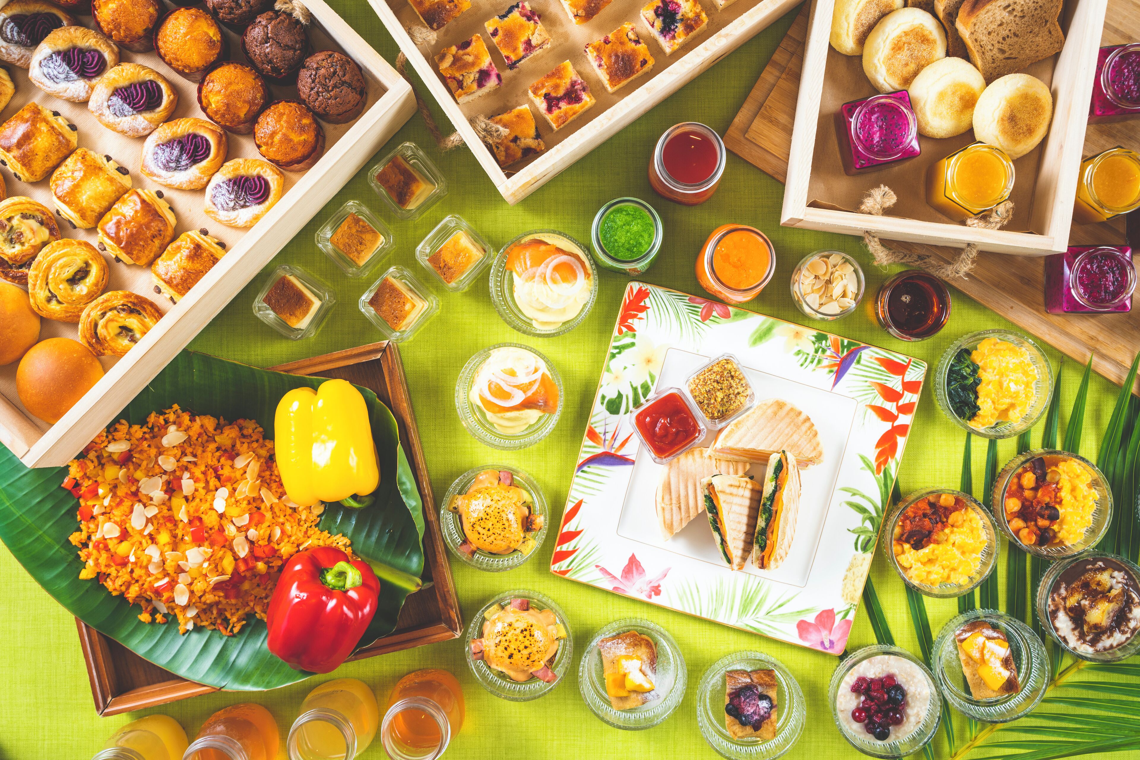 Diversos alimentos y bebidas dispuestos sobre una mesa con mantel verde.