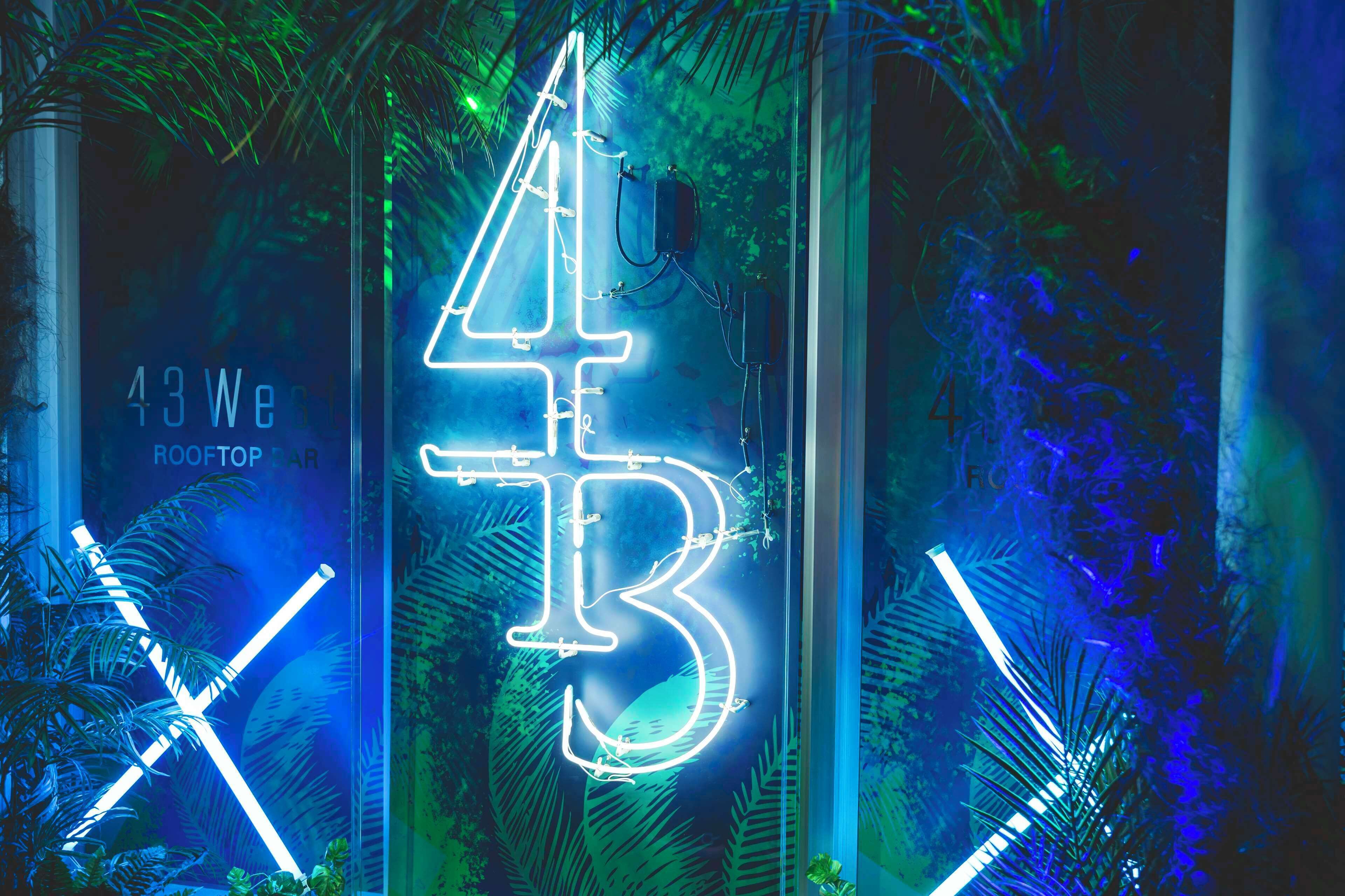 Un letrero de neón con el número 43 y la letra 'B' en una exhibición moderna e iluminada.
