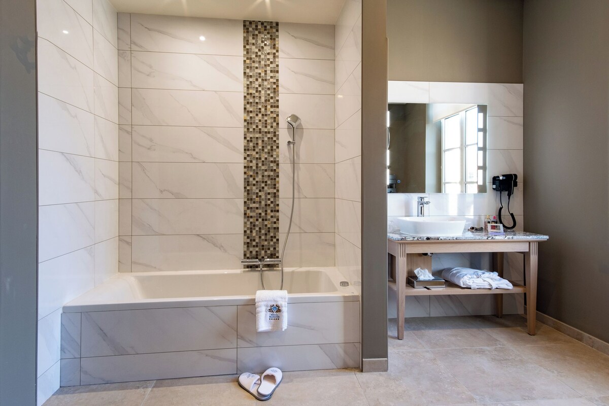 Une salle de bain moderne avec une grande baignoire, une douche et un meuble-lavabo avec un miroir.